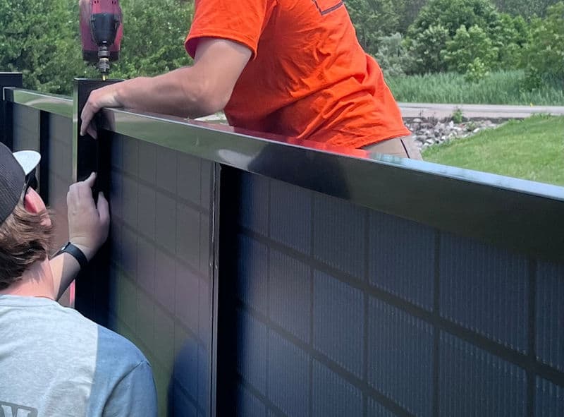 SOL Fence installation process with panels being mounted by contractors